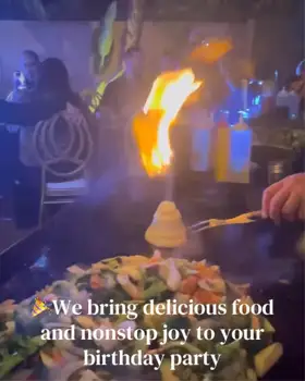 A hibachi chef performs a flaming onion volcano at a private backyard party in Union as guests enjoy the live teppanyaki experience.