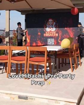 A hibachi chef performing fun cooking tricks, fire show, food tossing, and interactive entertainment for guests.