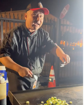 A hibachi chef tossing food to guests during a live private hibachi dinner, creating a fun and interactive party experience.